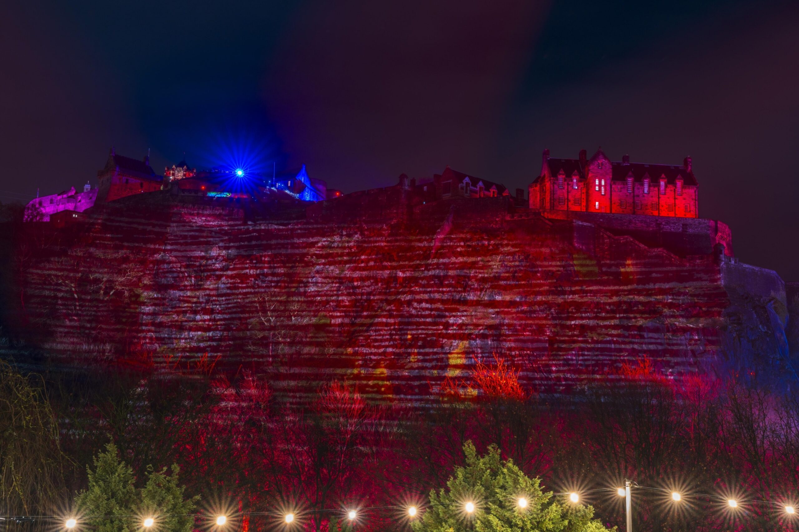 Castle lit red and purple at night